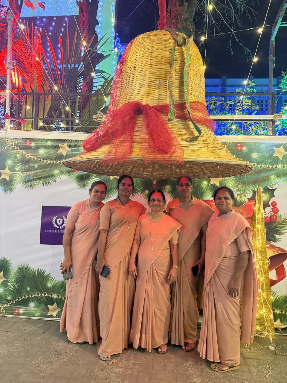 Christmas celebration beneath a large festive bell